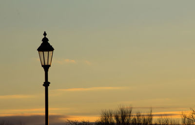 Street light against orange sky