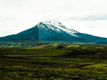 Scenic view of field and mountains against sky