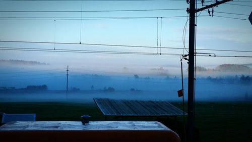 Power lines against cloudy sky