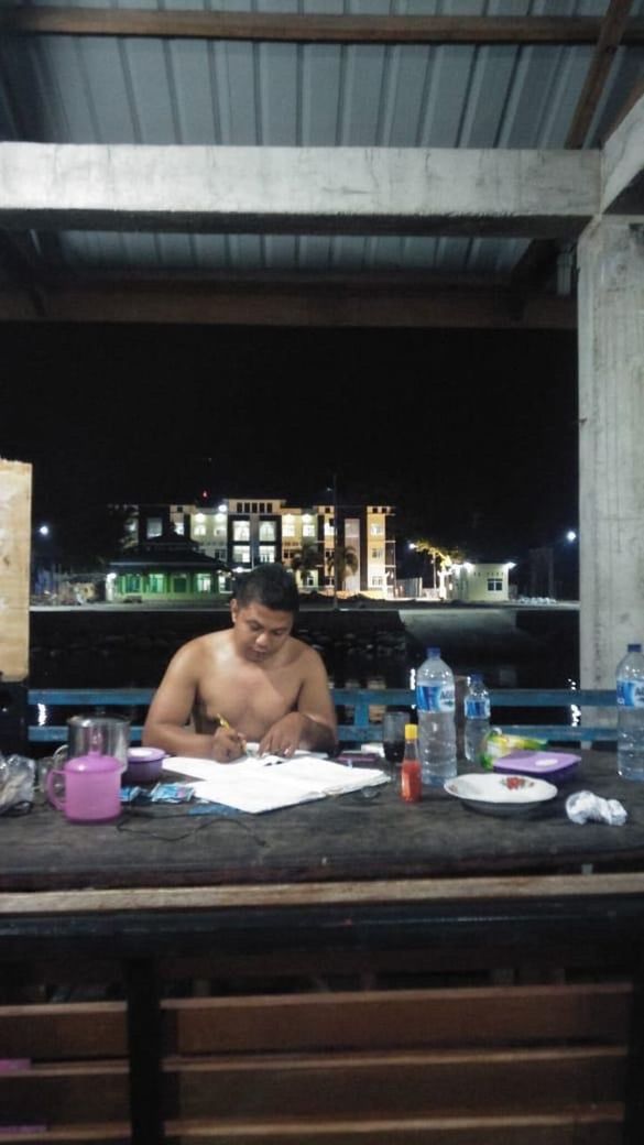 PORTRAIT OF SHIRTLESS MAN SITTING AT RESTAURANT TABLE