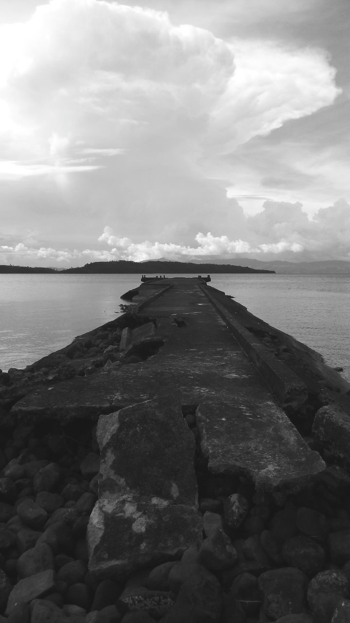 CLOSE-UP OF GROYNE ON SHORE AGAINST SKY