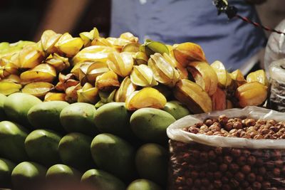 Midsection of vendor with fruits for sale at market