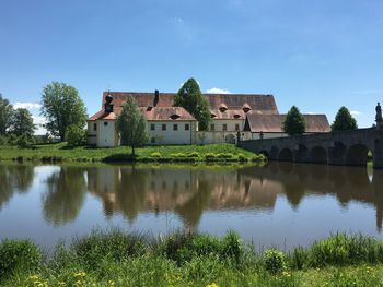 Houses by lake against sky