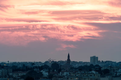 Buildings in city against sky during sunset