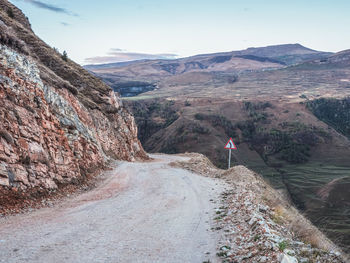 Rear view of man walking on mountain against sky