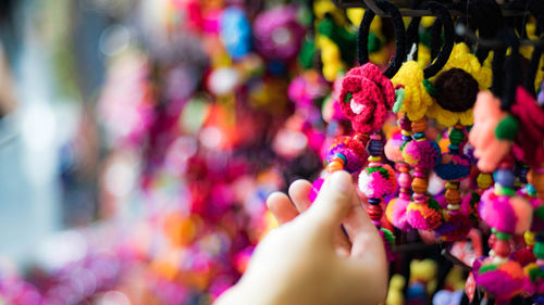 Cropped hand holding colorful rubber band at market stall