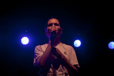 Full length of man standing against black background