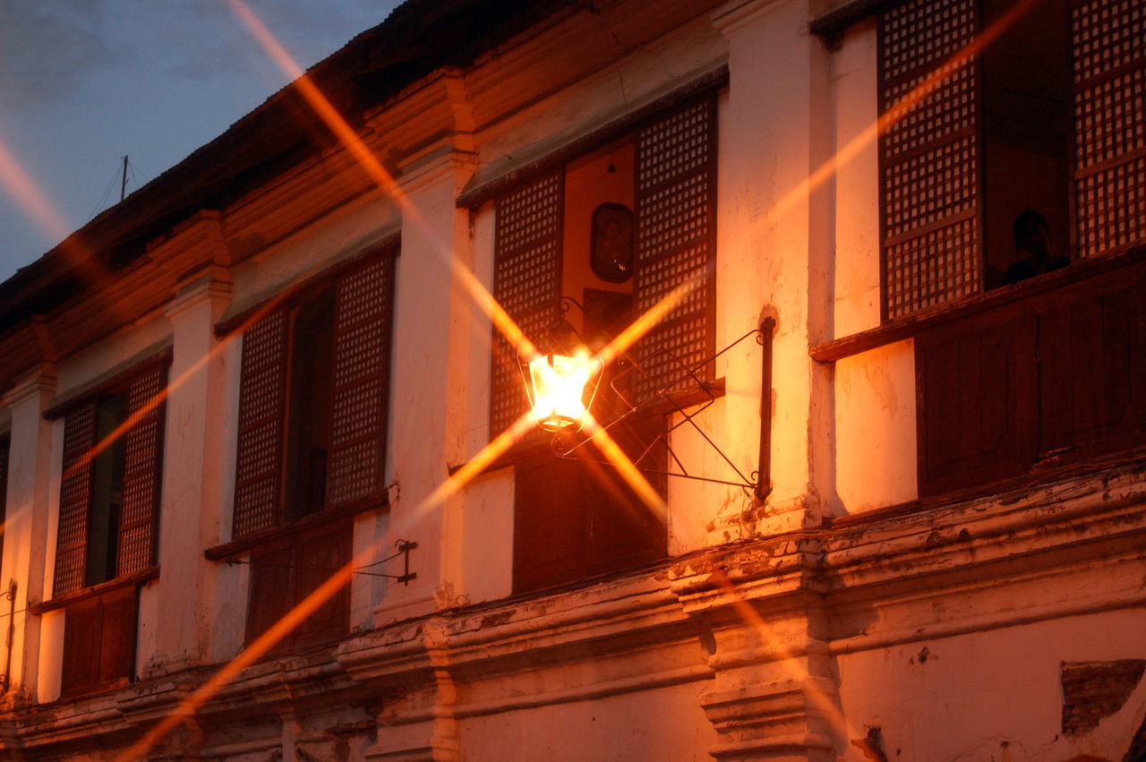 LOW ANGLE VIEW OF ILLUMINATED BUILDING AT SUNSET