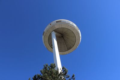 Low angle view of communications tower against clear blue sky