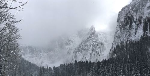 Panoramic view of snow covered mountains against sky