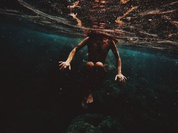 Low section of man swimming in sea