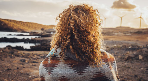 Rear view of woman sitting on field