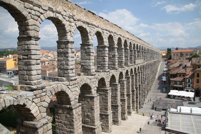 Roman aqueduct by buildings in city