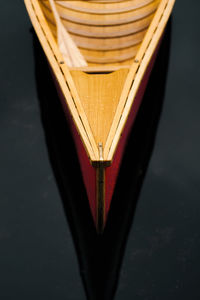 Bow, nose of a beautiful wooden canoe boat on the water. boat floating on dark water, no people