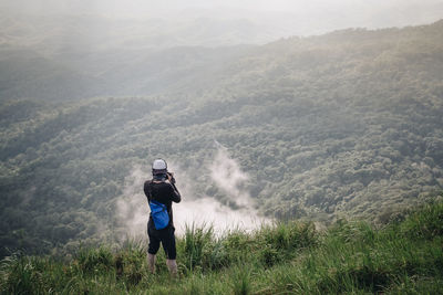 Man standing on mountain against forest