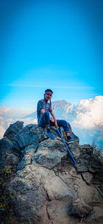 Man on rock against sky