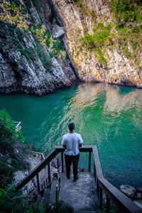 High angle view of man standing by lake against mountains