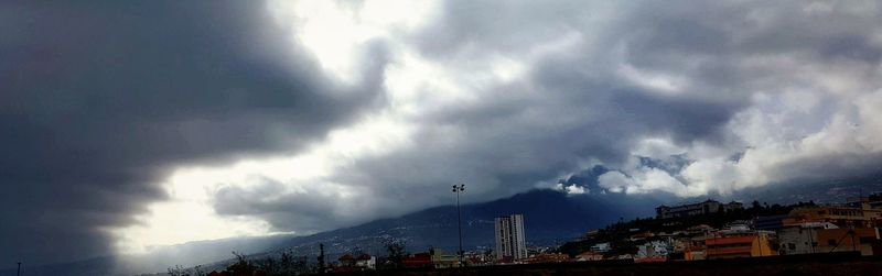 Low angle view of buildings against cloudy sky