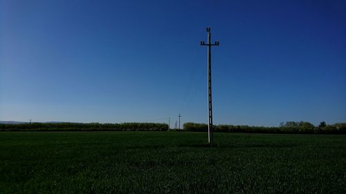 Scenic view of field against clear blue sky