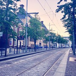 Railroad tracks in city against sky