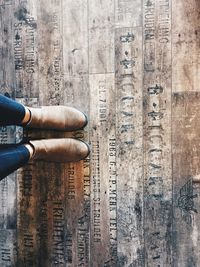 Low section of woman with text on wooden planks