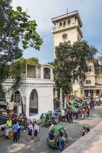 People on street against buildings in city