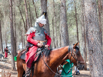 Man riding horse cart on tree trunk