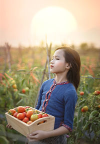 Cute girl holding fruits on field