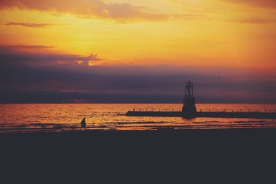 Silhouette of lighthouse at seaside