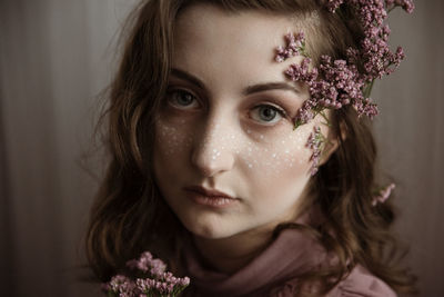 Close-up portrait of beautiful young woman wearing flowers