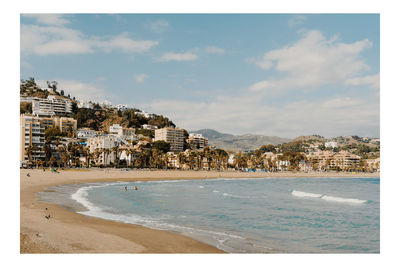 View of townscape by sea against sky