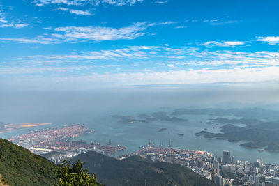 Aerial view of city by sea against sky
