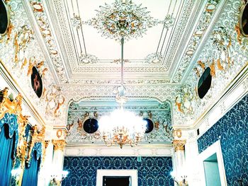 Low angle view of chandelier hanging on ceiling in building