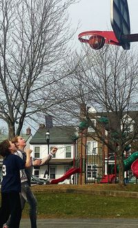 Man playing with basketball hoop against sky