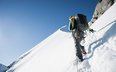 Low angle view of person skiing on snow against sky