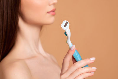 Midsection of woman holding razor