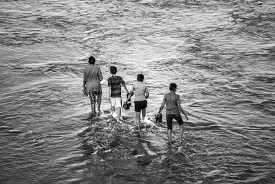 Four teenage boys in shallow water