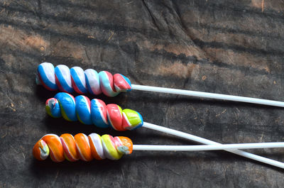 High angle view of colorful lollipops on black paper