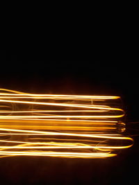 Close-up of illuminated lighting equipment against black background