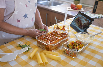 Midsection of senior woman preparing food on table