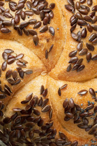 Single round bread roll with dark sesame seeds, top view, close up, vertical composition