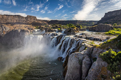 Scenic view of waterfall against sky