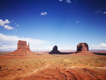 Panoramic view of desert against blue sky