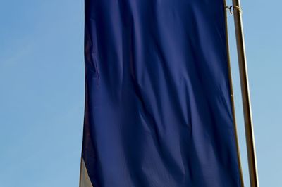 Low angle view of flag against clear blue sky