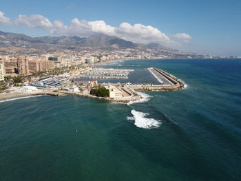 High angle view of cityscape by sea against sky