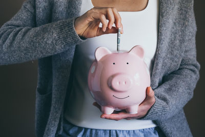Woman putting bill in piggy bank. saving money. economic crisis