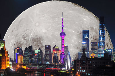 Low angle view of illuminated cityscape against sky at night