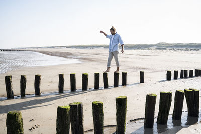 Rear view of man photographing on beach