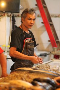 Portrait of chef making seafood in commercial kitchen