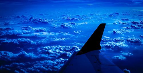 Low angle view of airplane wing against sky